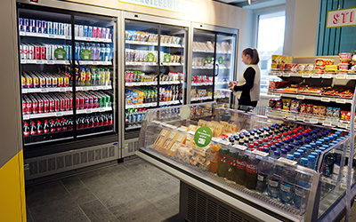 Eine Frau kauft im Kiosk ein.