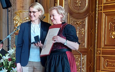 Augsburgs Oberbürgermeisterin Eva Weber (links) verleiht Elisabeth Hochgesand, Vorstandsmitglied des Freundeskreis Josefinum e. V. (rechts), die städtische Verdienstmedaille „Für Augsburg“. Foto: KJF Augsburg / Sabine Berninger 